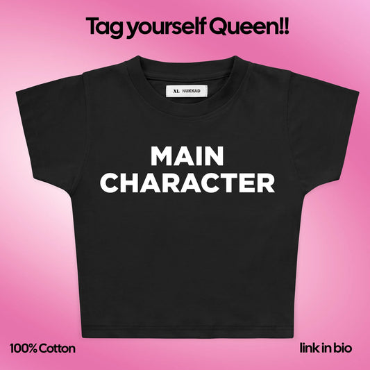 Black t-shirt with 'MAIN CHARACTER' text on a pink gradient background